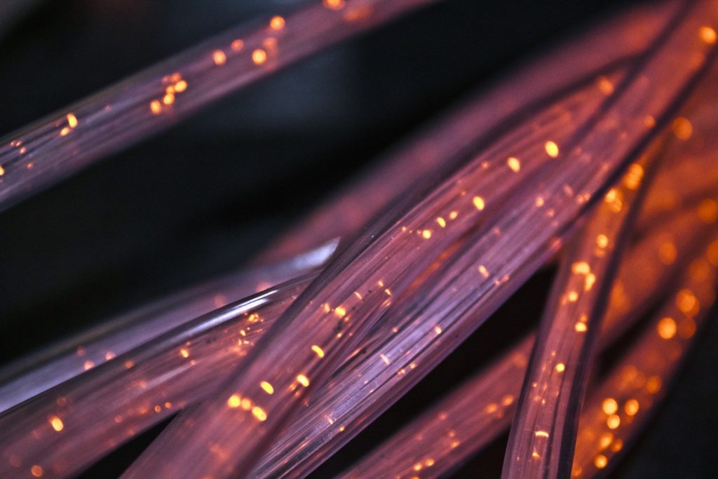 a cluster of fibre optic network cables glowing against a dark background